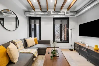 a living room with a couch and a flat screen tv at Modern Parkdale Getaway 1-Bedroom Parking in Toronto