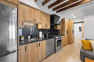 a kitchen with wooden cabinets and stainless steel appliances at Modern Parkdale Getaway 1-Bedroom Parking in Toronto