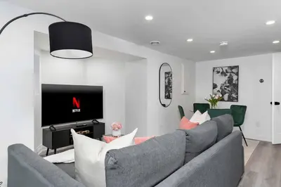 a living room with a gray couch and a tv at Modern 1-BR Condo with Parking in Downtown Toronto in Toronto