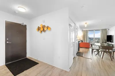 a living room with a door and a dining room at Modern Lakefront Esc Stylish 2BR Condo with Patio in Toronto