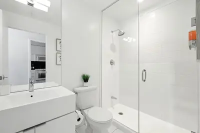 a white bathroom with a toilet and a shower at Gorgeous 2BR in Downtown Toronto w City Views in Toronto