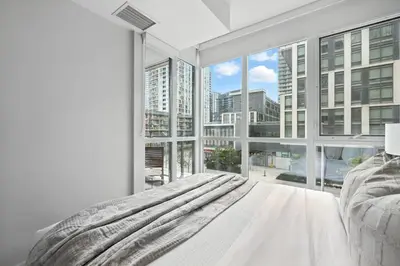 a bedroom with a bed and a large window at Gorgeous 2BR in Downtown Toronto w City Views in Toronto