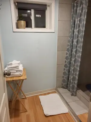 a bathroom with a shower with a table and a window at 75 inch high mud house with separate entrance and exit, one bedroom, one living room, private bathroom, there is a cute cat, a few minutes walk to many restaurants, 8 minutes drive to the big waterfall in Niagara Falls