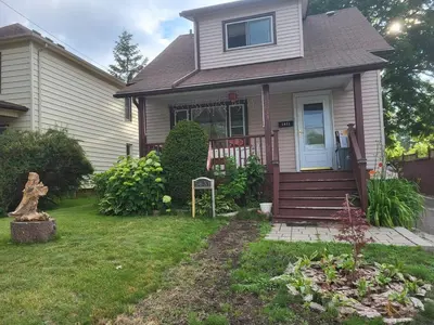 a house with a porch and a yard at 75 inch high mud house with separate entrance and exit, one bedroom, one living room, private bathroom, there is a cute cat, a few minutes walk to many restaurants, 8 minutes drive to the big waterfall in Niagara Falls