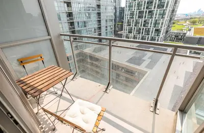 a balcony with a bench and chair on a building at Spacious 1 Bedroom plus Den Condo Iceboat Terrace Downtown Toronto in Toronto