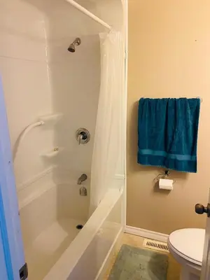 a bathroom with a shower with a blue towel at Peterborough Cosy Apartment in Peterborough