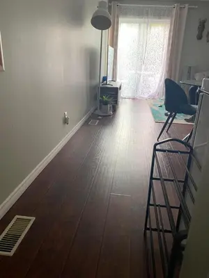 a living room with a wooden floor and a window at Peterborough Cosy Apartment in Peterborough