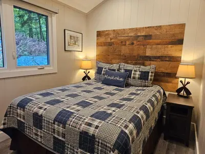 a bedroom with a bed with a wooden headboard and two lamps at Olga's Bay Lake House in Minett