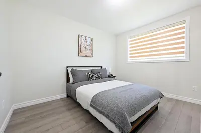 a white bedroom with a bed and a window at The Hamilton Haven in Hamilton