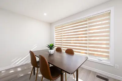 a dining room with a table and chairs and a window at The Hamilton Haven in Hamilton