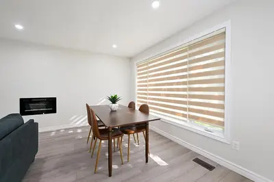 a dining room with a table and a couch at The Hamilton Haven in Hamilton
