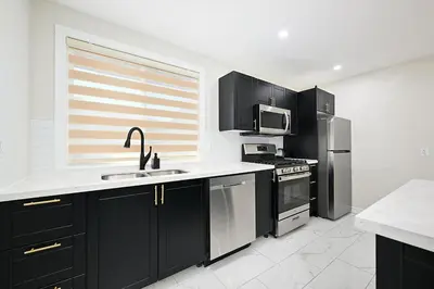 a kitchen with black cabinets and stainless steel appliances at The Hamilton Haven in Hamilton