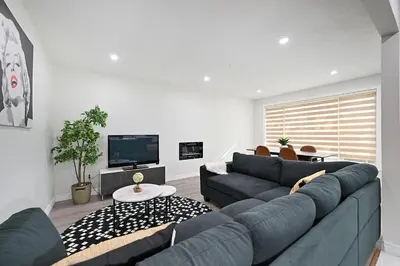 a living room with a blue couch and a tv at The Hamilton Haven in Hamilton