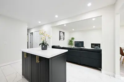 a kitchen and living room with a black couch at The Hamilton Haven in Hamilton