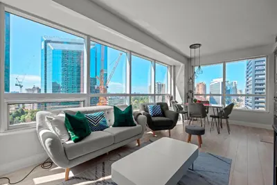 a living room with a couch and some windows at Panoramic 2 Bedroom 2 Bathroom Condo Sheppard Metro North York Toronto in Toronto