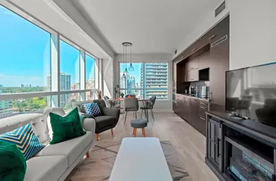 a living room with a couch and a television at Panoramic 2 Bedroom 2 Bathroom Condo Sheppard Metro North York Toronto in Toronto