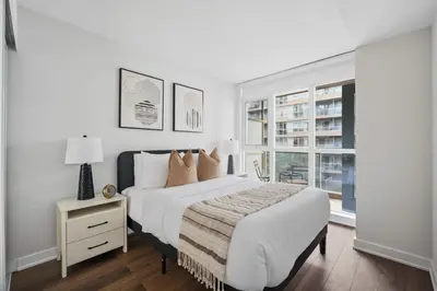 a white bedroom with a bed and a window at Trendy 1BR Condo Free Parking Downtown Toronto in Toronto