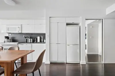 a kitchen with a wooden table and a refrigerator at Trendy 1BR Condo Free Parking Downtown Toronto in Toronto