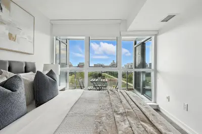 a bedroom with a bed and a large window at Modern 2BR Condo Stunning Views Walk Everywhere in Toronto