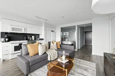 a living room with a gray couch and a kitchen at Modern 2BR Condo Stunning Views Walk Everywhere in Toronto