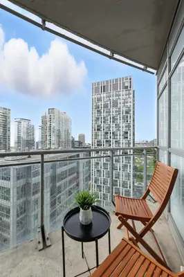 a chair and a table on a balcony with a view at Family-Friendly Sleep 8 Steps to all Attractions in Toronto