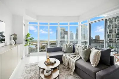 a living room with a couch and a large window at Family-Friendly Sleep 8 Steps to all Attractions in Toronto