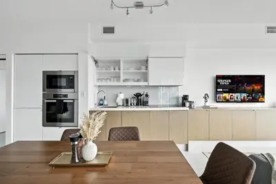 a kitchen and dining room with a wooden table and chairs at Family-Friendly Sleep 8 Steps to all Attractions in Toronto