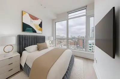 a bedroom with a bed and a flat screen tv at Ritzdale Suites - Toronto's Entertainment District in Toronto