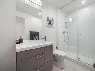 a bathroom with a sink and a toilet and a shower at Ritzdale Suites - Toronto's Entertainment District in Toronto