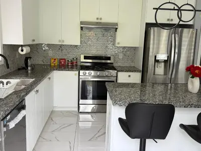 a kitchen with a stove and a black chair in it at masters bet room in Whitby