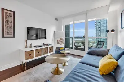 a living room with a blue couch and a table at Lakeview 1-Bedroom Condo-Downtown Toronto-Free Parking in Toronto