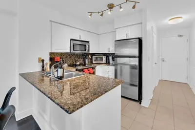a kitchen with a sink and a refrigerator at Lakeview 1-Bedroom Condo-Downtown Toronto-Free Parking in Toronto