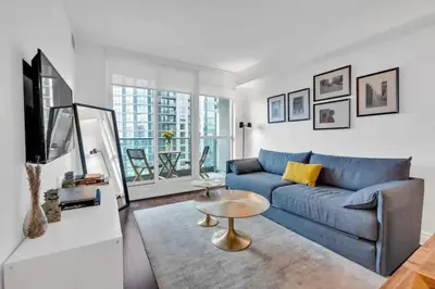 a living room with a blue couch and a table at Lakeview 1-Bedroom Condo-Downtown Toronto-Free Parking in Toronto