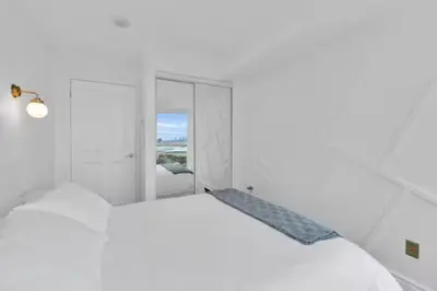 a white bedroom with a white bed and a window at Lakeview 1-Bedroom Condo-Downtown Toronto-Free Parking in Toronto