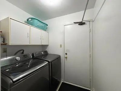 a laundry room with a sink and a washing machine at Spacious 2-BR Basement Suite Near Lake Simcoe & Beach Park in Innisfil
