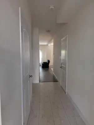 an empty hallway with a couch in the distance at Modern 3BR Home Near Niagara Falls & Welland Canal in Welland