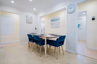 a dining room with a table and chairs and a clock at Bright, Modern & Cozy Getaway Home in the GTA in Whitby