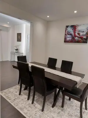a dining room table with chairs and a piano at Modern 5-bedroom house close to Ardagh Bluffs in Barrie