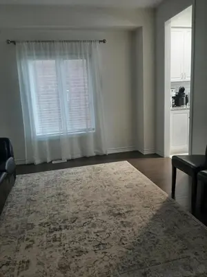 an empty living room with a window and a rug at Modern 5-bedroom house close to Ardagh Bluffs in Barrie