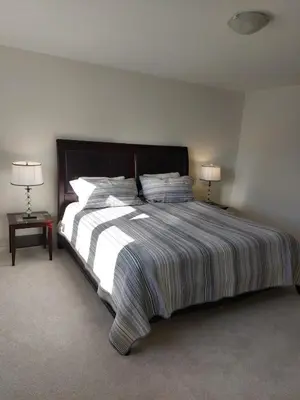 a bedroom with a large bed with two lamps at Modern 5-bedroom house close to Ardagh Bluffs in Barrie