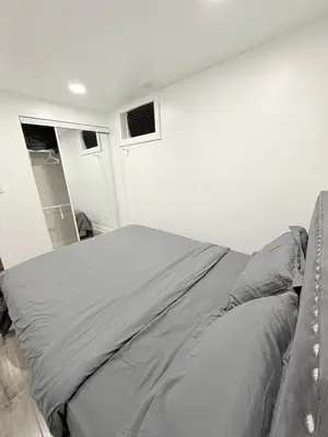 a bedroom with a gray bed in a room at Modern & cozy one Bedroom Basement Suite with Kitchen and parking- sleeps 4 in Mississauga