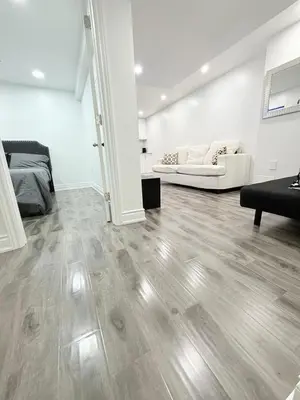 a living room with a wooden floor and a couch at Modern & cozy one Bedroom Basement Suite with Kitchen and parking- sleeps 4 in Mississauga
