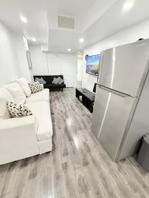 a living room with a refrigerator and a couch at Modern & cozy one Bedroom Basement Suite with Kitchen and parking- sleeps 4 in Mississauga