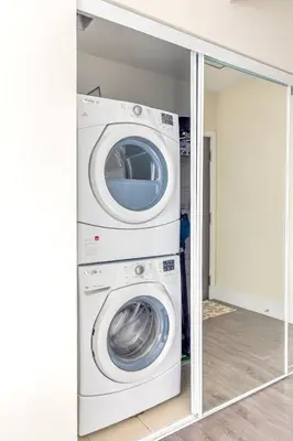 a washer and dryer in a room with a mirror at Luxury 1BR Suite w Skyline City Views - The Roland in Toronto