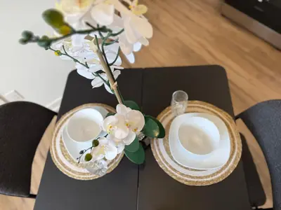 a table with two plates and a vase with flowers at Bright Escape Falls Retreat in Niagara Falls