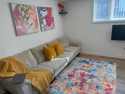 a living room with a couch and a rug at Bright Escape Falls Retreat in Niagara Falls