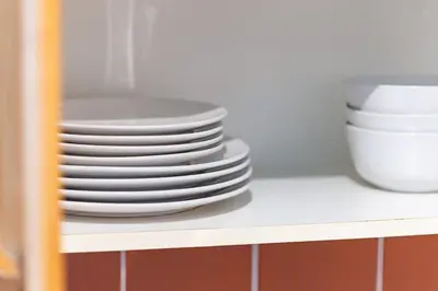 a stack of plates and bowls on a shelf at Chic Fort York Studio Cozy Retreat in Downtown TO in Toronto