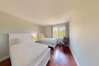 a bedroom with a bed and a chair and a window at Wintergreen 222 in Blue Mountains