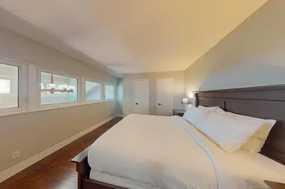 a bedroom with a bed and two windows at Wintergreen 222 in Blue Mountains