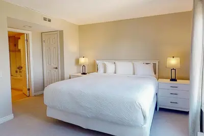 a bedroom with a large white bed with two lamps at Sierra Lane 218 in Blue Mountains